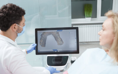 A man and woman in white lab coats are discussing a dental treatment plan.