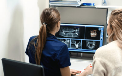 Two women examining a full arch restoration x-ray.