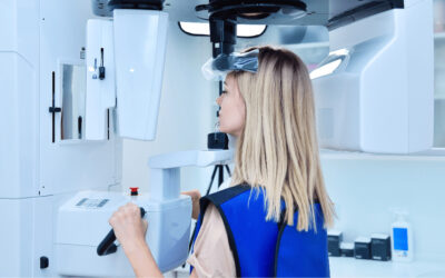 A woman in a lab conducting dental research while looking into a microscope.